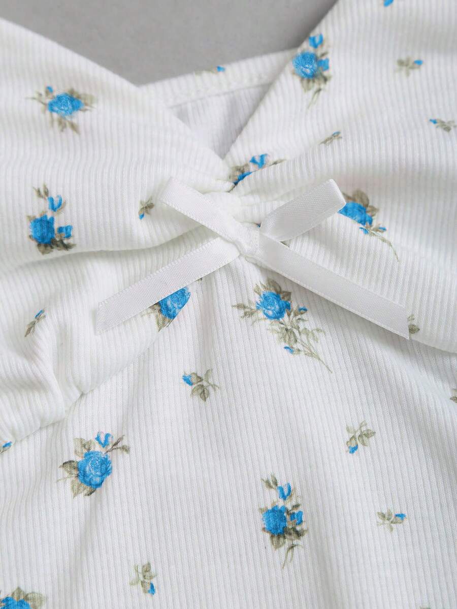 Women's short sleeve knit top with a sweetheart neckline and ruched twist knot front detail.