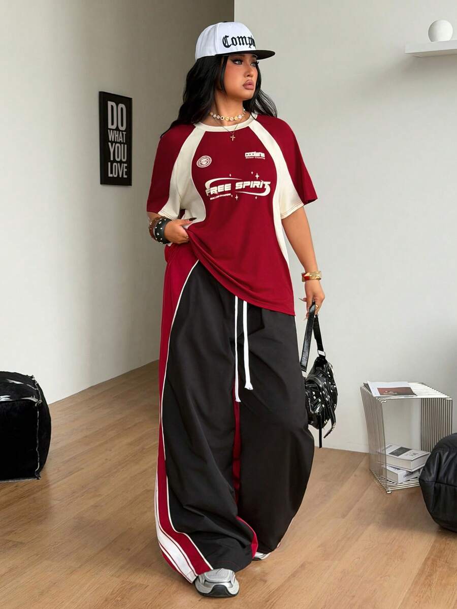 Unisex plus size oversized jersey t-shirt in brown featuring a round neck, short raglan sleeves with contrast binding, and a front letter graphic print.
