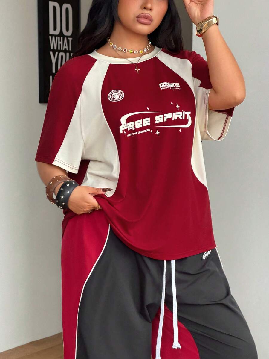 Unisex plus size oversized jersey t-shirt in brown featuring a round neck, short raglan sleeves with contrast binding, and a front letter graphic print.