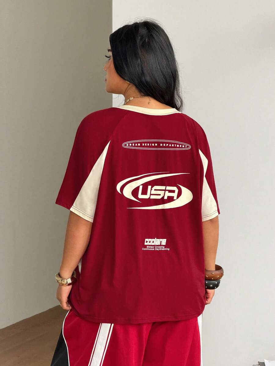 Unisex plus size oversized jersey t-shirt in brown featuring a round neck, short raglan sleeves with contrast binding, and a front letter graphic print.