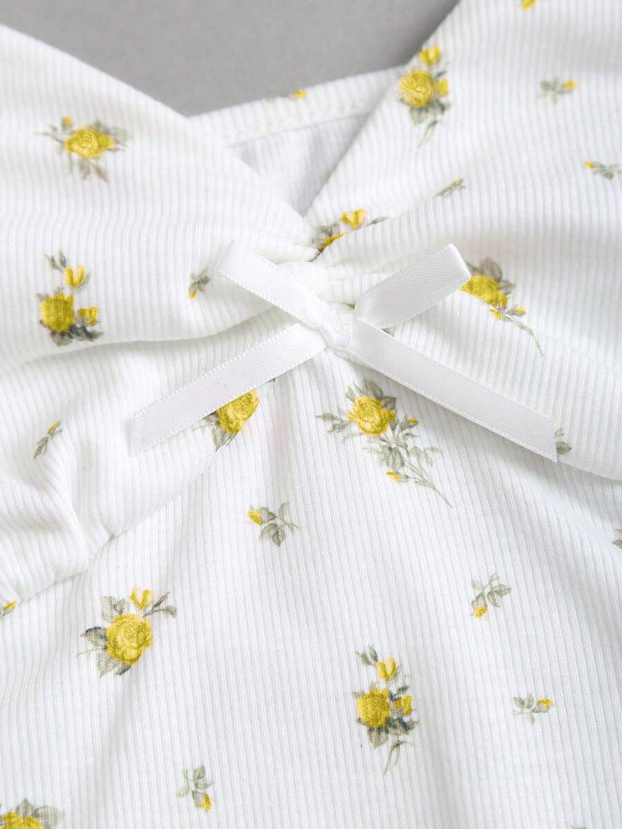 Women's short sleeve knit top with a sweetheart neckline and ruched twist knot front detail.