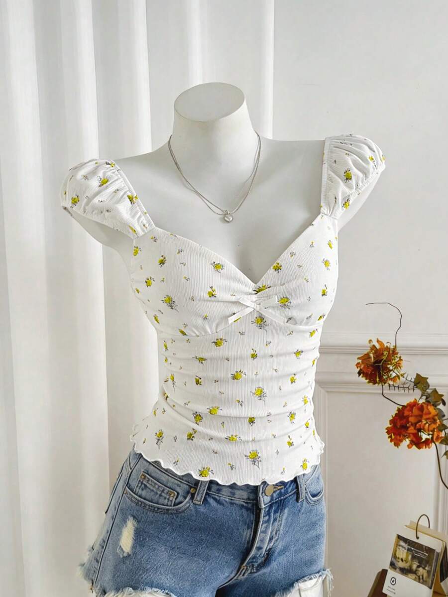 Women's short sleeve knit top with a sweetheart neckline and ruched twist knot front detail.