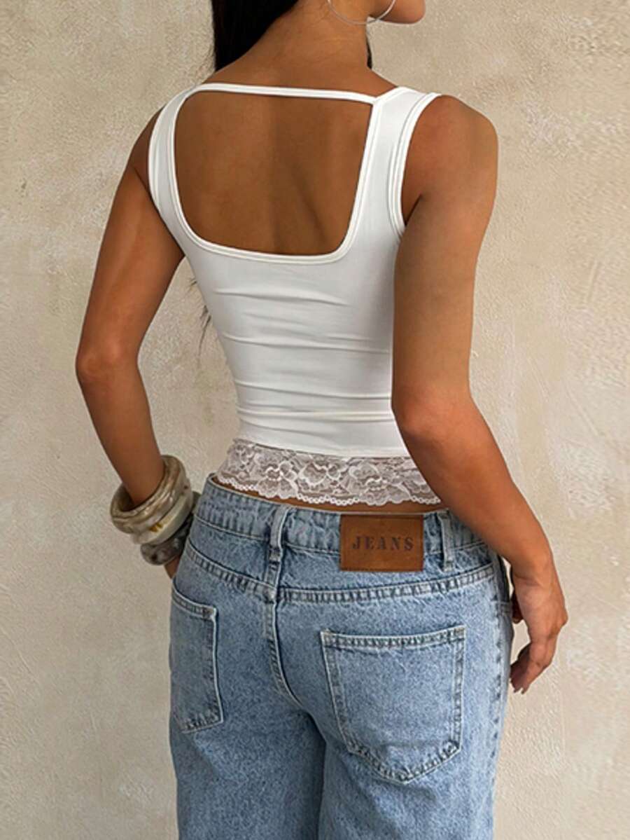 Women's white sleeveless crop tank top with contrast lace details, strap neckline, and graphic plant pattern in a slim fit.