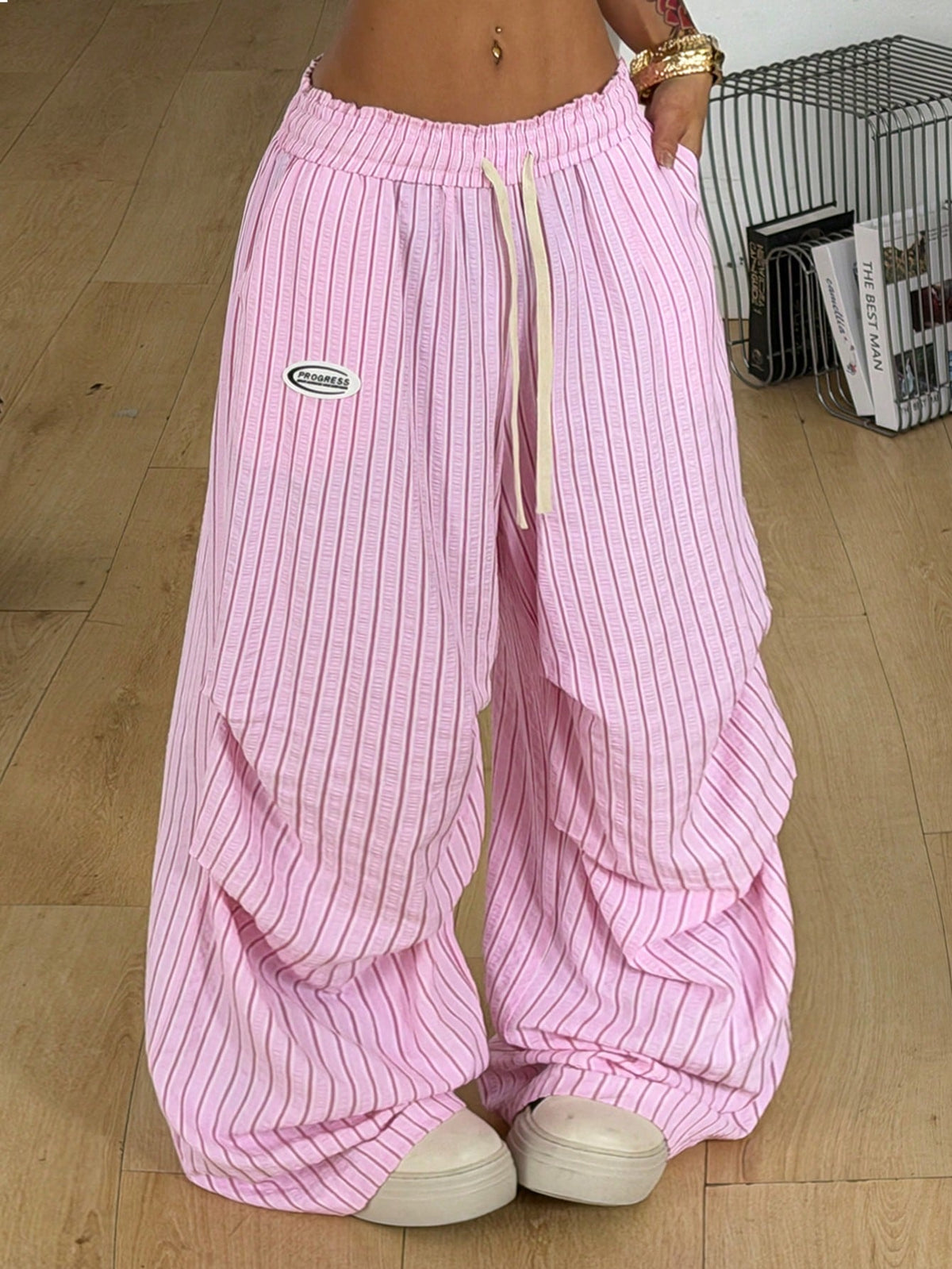 Women's black and white striped wide leg pants featuring an elastic drawstring waistband, side pockets, and a loose straight leg fit.