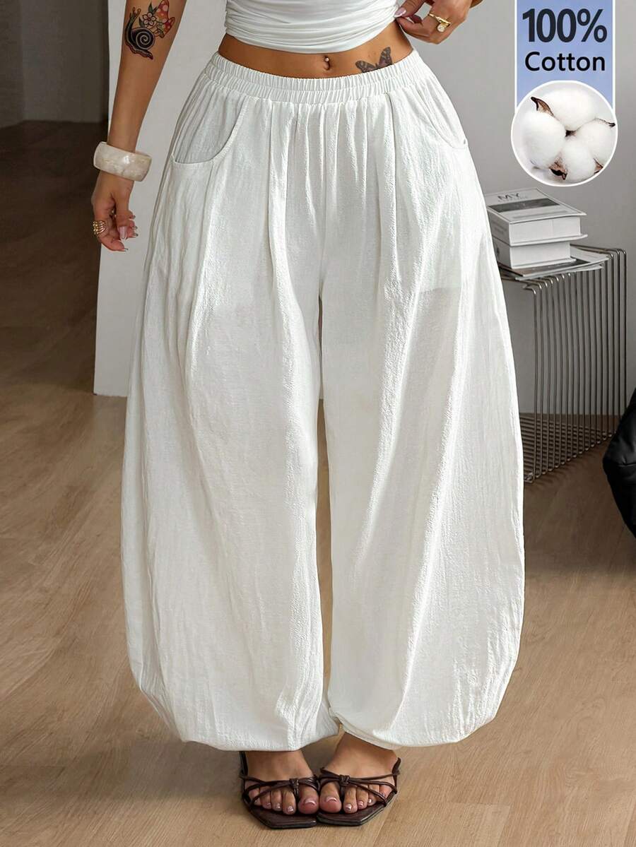 Women's loose-fit black bloomer pants made of 100% cotton featuring an elastic waistband and side pockets.
