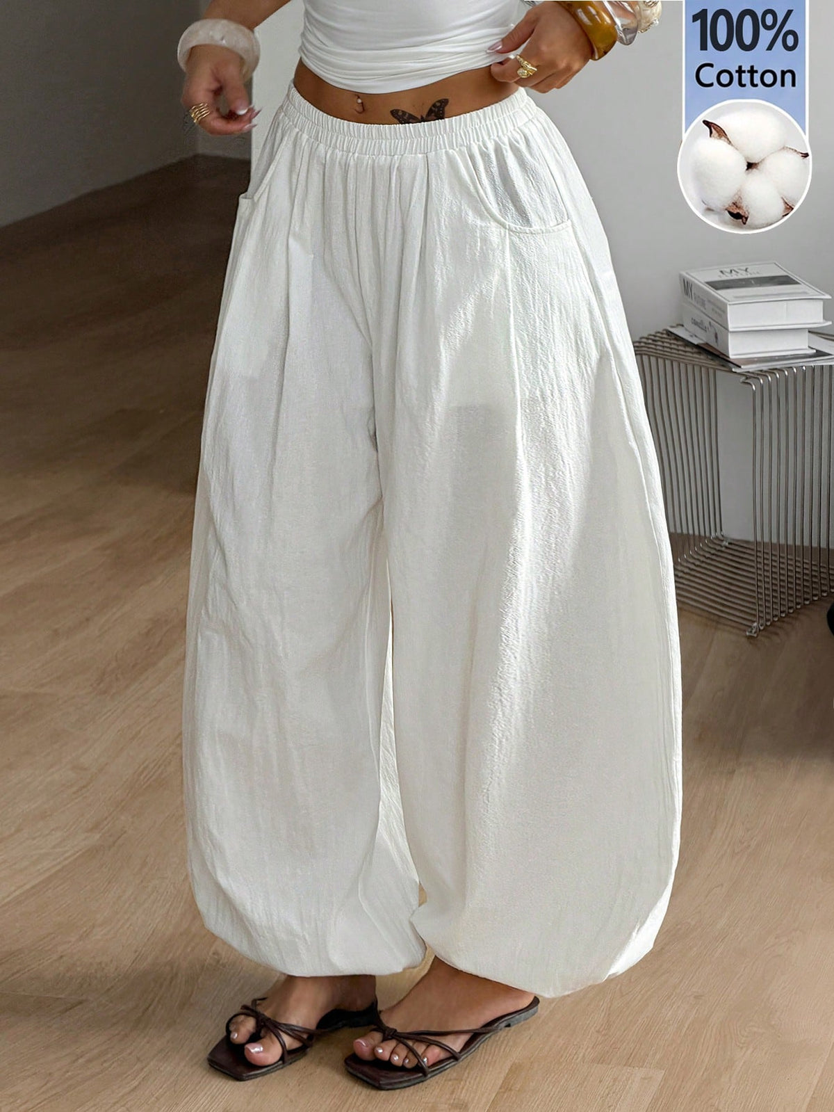Women's loose-fit black bloomer pants made of 100% cotton featuring an elastic waistband and side pockets.
