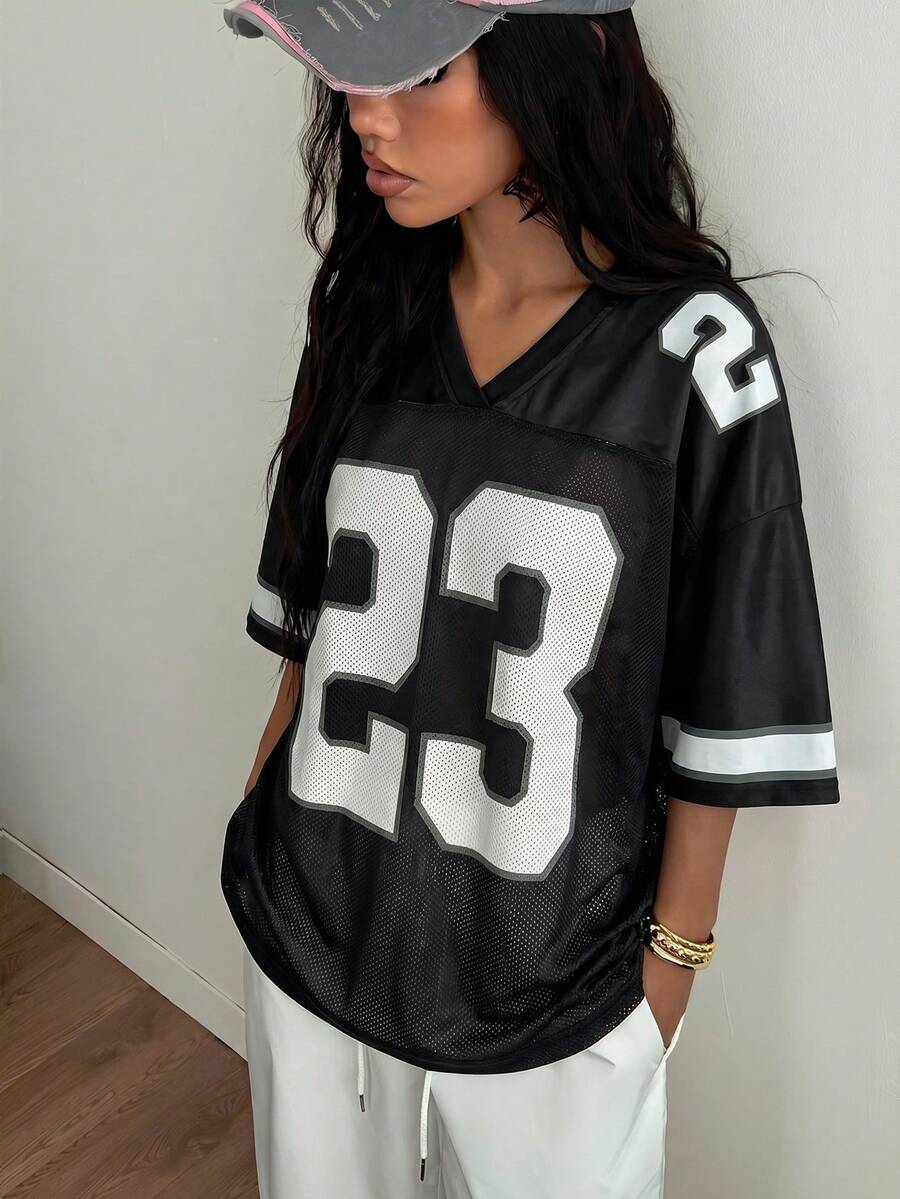 Oversized short-sleeve football jersey top featuring a V-neckline, contrast binding, and graphic number print.