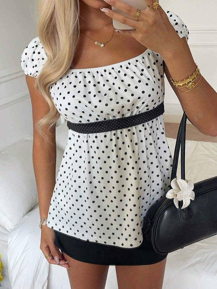 Women's short sleeve square neck polka dot top with ruched detailing, flared hem, and waist tie back.