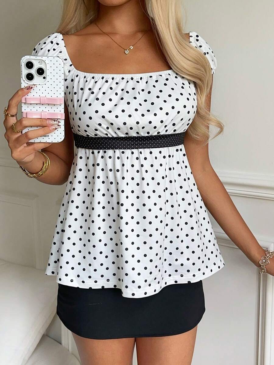 Women's short sleeve square neck polka dot top with ruched detailing, flared hem, and waist tie back.