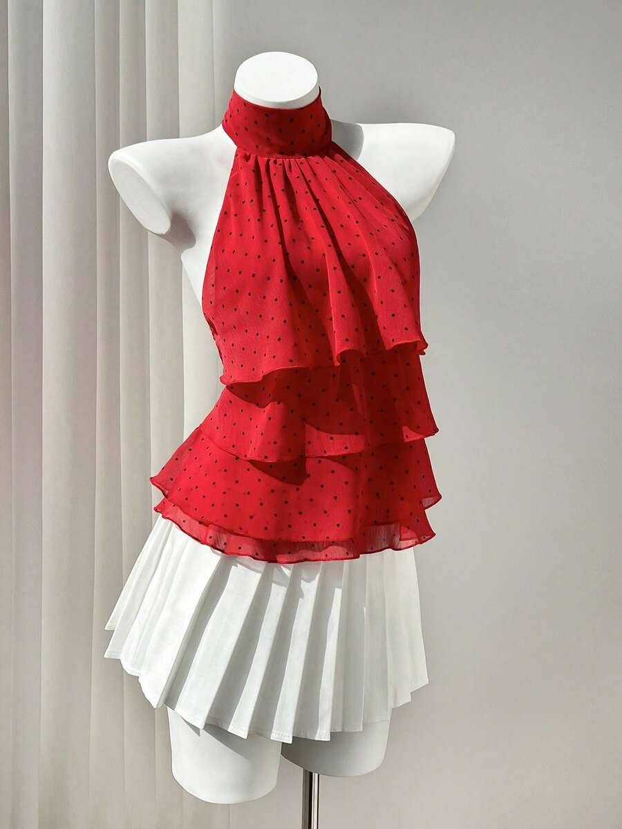 Women's white sleeveless halter neck top featuring pleated fabric, backless tie strap design, and a flared layered ruffle hem.