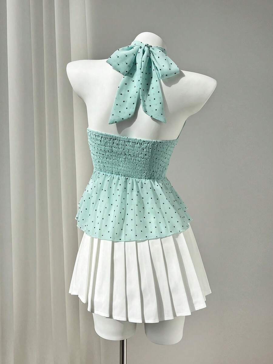 Women's white sleeveless halter neck top featuring pleated fabric, backless tie strap design, and a flared layered ruffle hem.