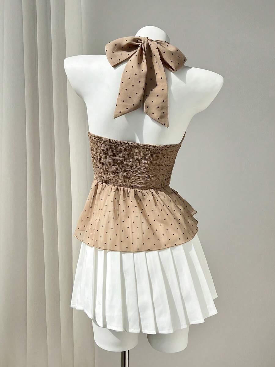 Women's white sleeveless halter neck top featuring pleated fabric, backless tie strap design, and a flared layered ruffle hem.
