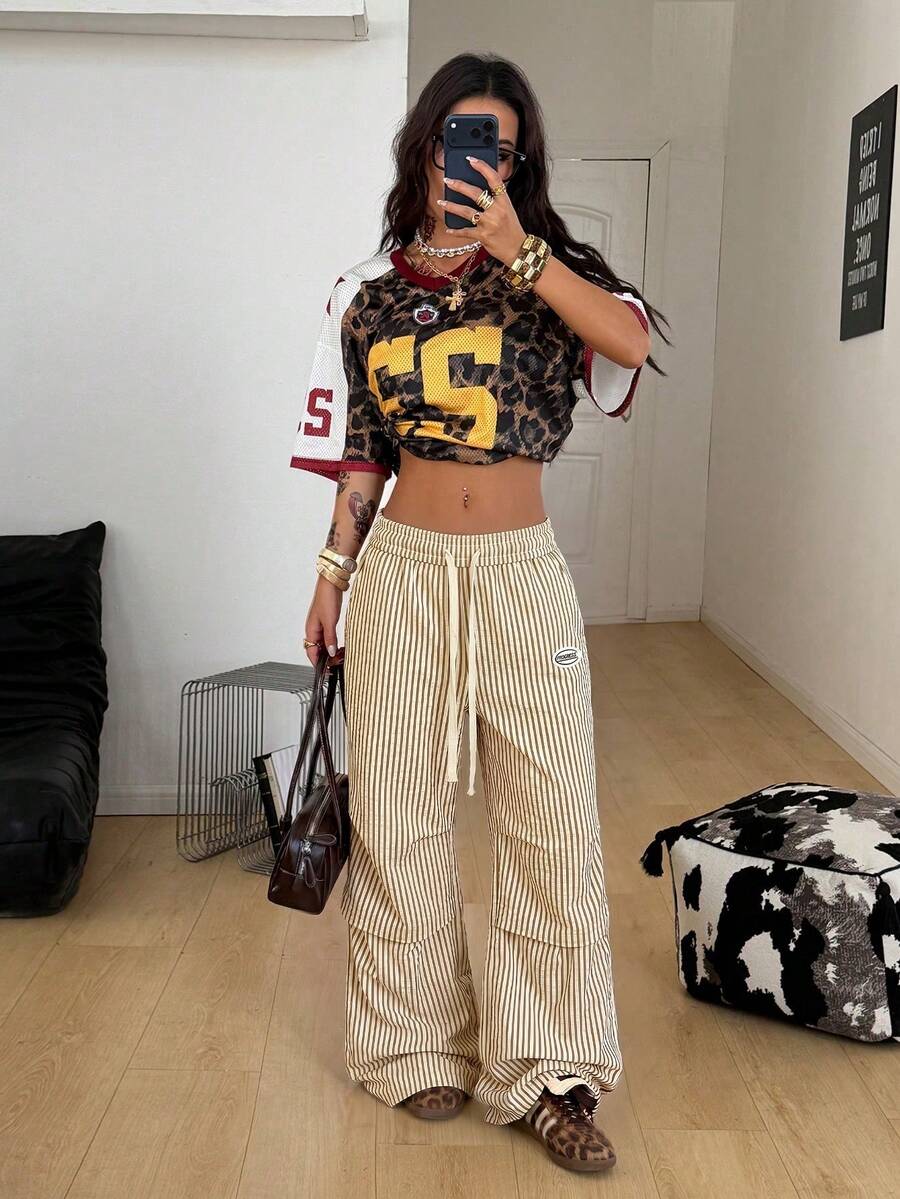 Women's black and white striped wide leg pants featuring an elastic drawstring waistband, side pockets, and a loose straight leg fit.