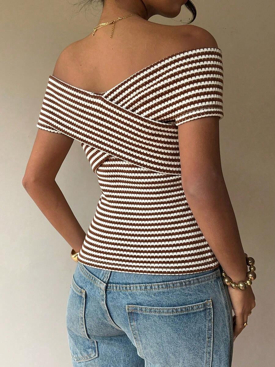 Women's striped short sleeve cold shoulder top featuring a slim fit, criss cross wrap details, and ribbed knitted fabric in apricot.