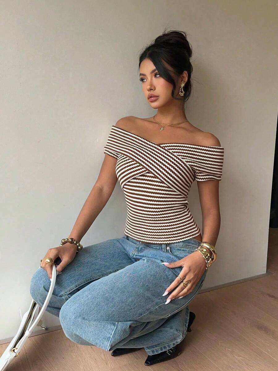 Women's striped short sleeve cold shoulder top featuring a slim fit, criss cross wrap details, and ribbed knitted fabric in apricot.