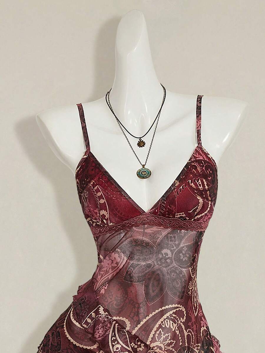 Women's graphic print camisole top featuring thin spaghetti straps, a backless cut, and an asymmetrical hem.