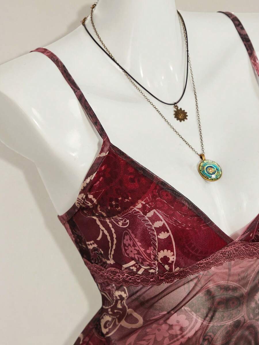 Women's graphic print camisole top featuring thin spaghetti straps, a backless cut, and an asymmetrical hem.