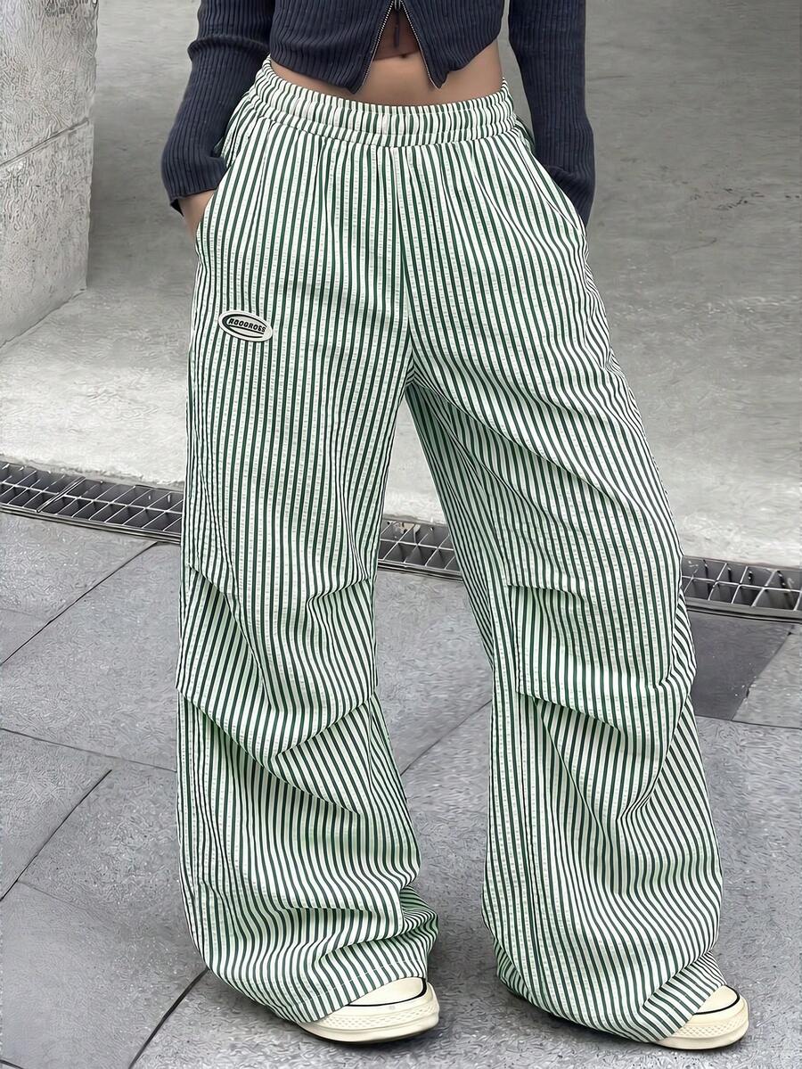 Women's black and white striped wide leg pants featuring an elastic drawstring waistband, side pockets, and a loose straight leg fit.