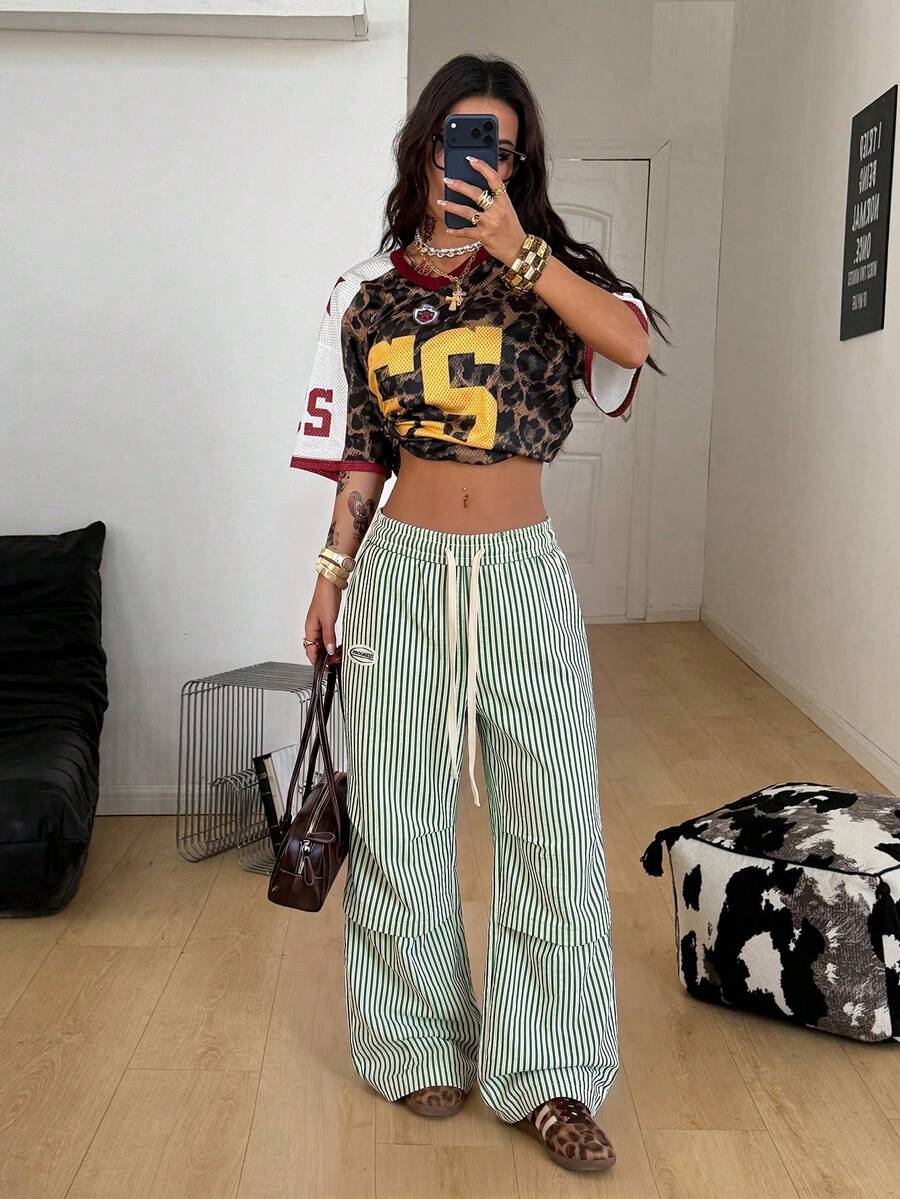Women's black and white striped wide leg pants featuring an elastic drawstring waistband, side pockets, and a loose straight leg fit.