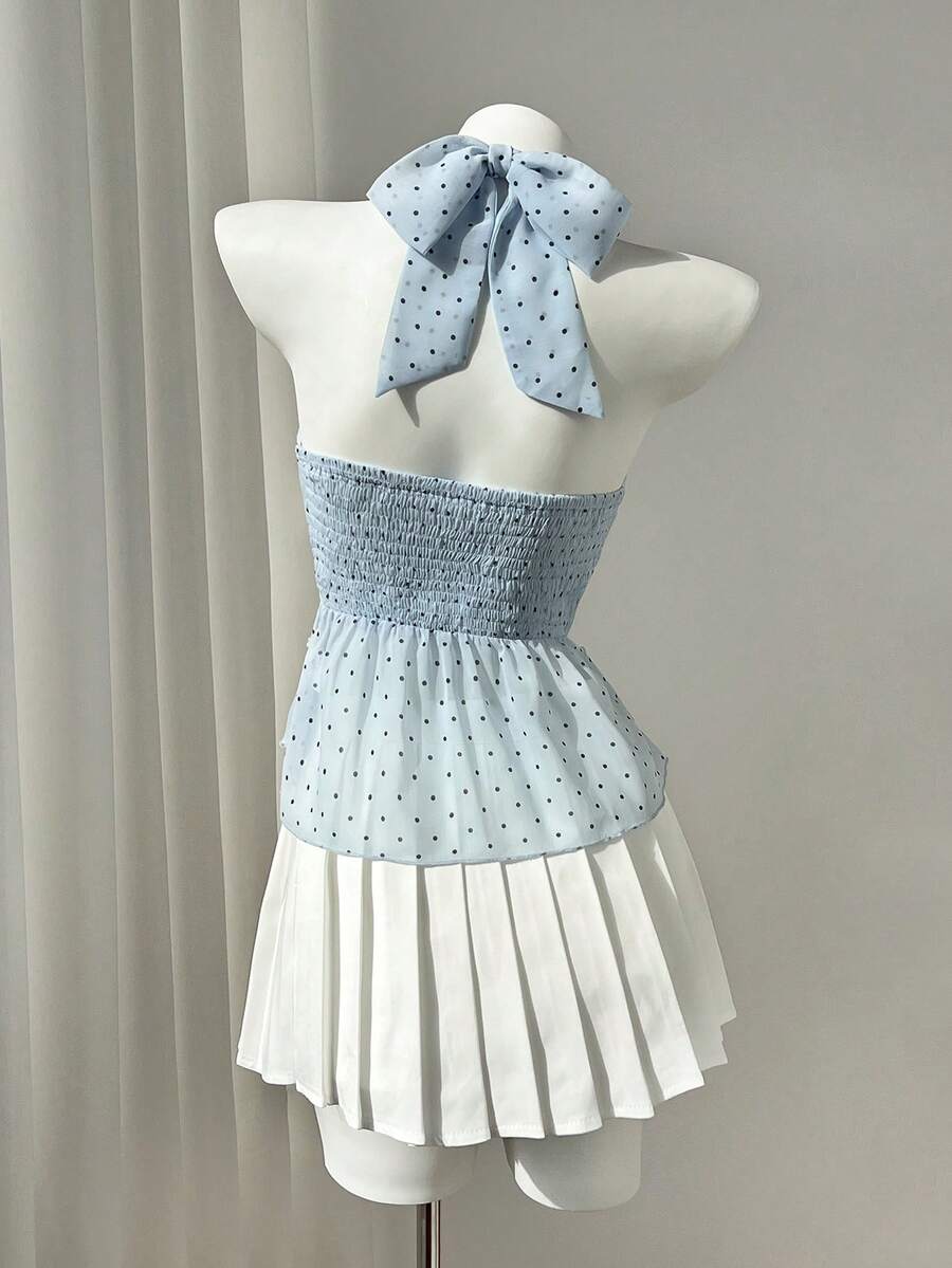 Women's white sleeveless halter neck top featuring pleated fabric, backless tie strap design, and a flared layered ruffle hem.