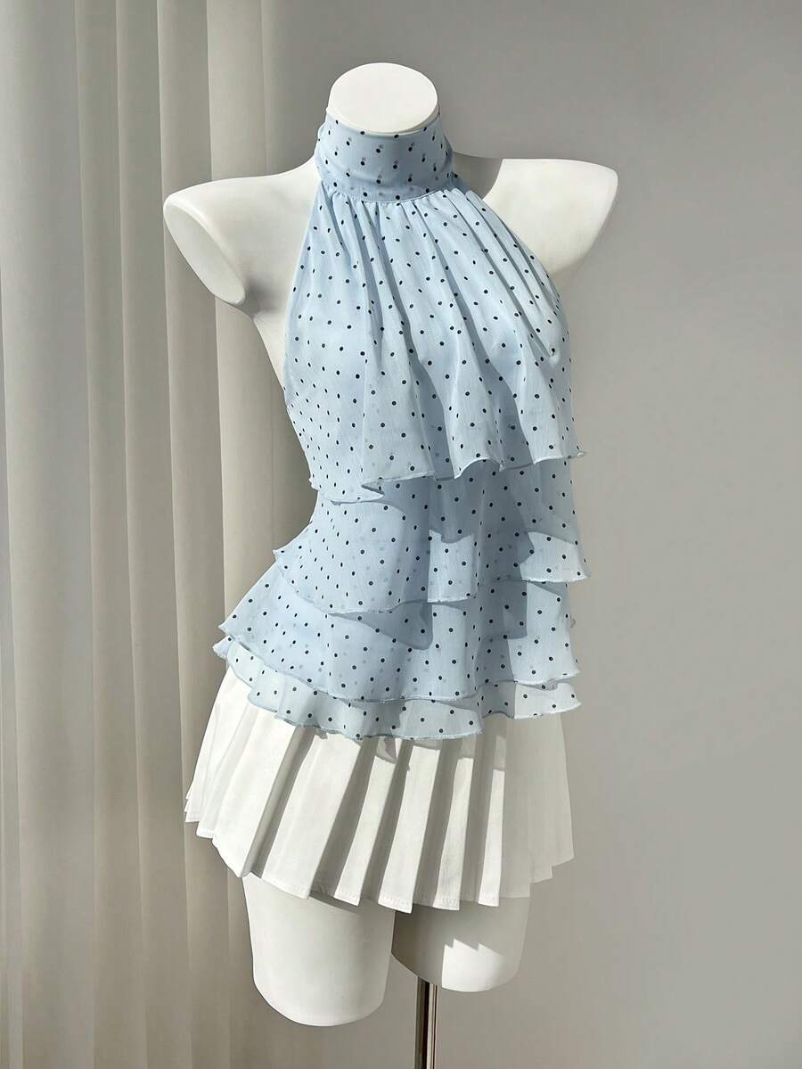 Women's white sleeveless halter neck top featuring pleated fabric, backless tie strap design, and a flared layered ruffle hem.