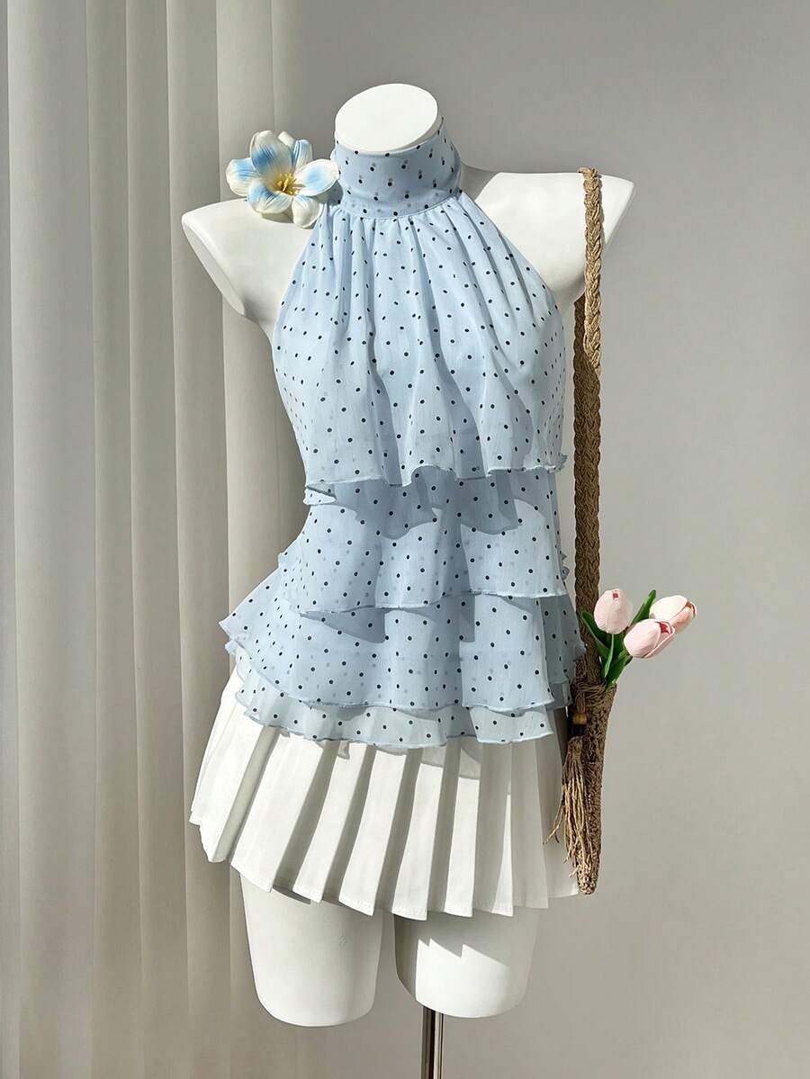 Women's white sleeveless halter neck top featuring pleated fabric, backless tie strap design, and a flared layered ruffle hem.