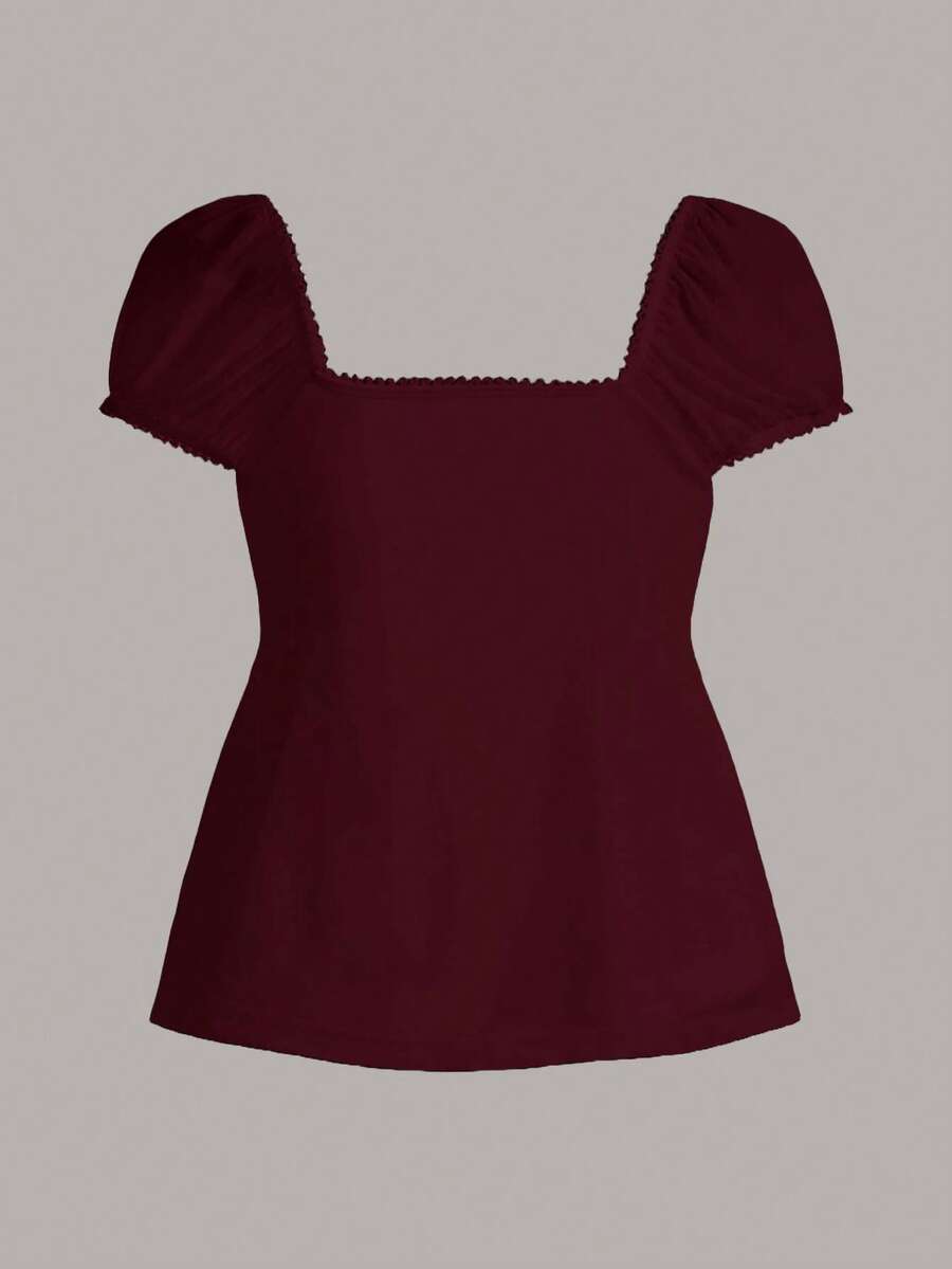 Women's black short puff sleeve top featuring a square neckline, ruched bust detail, and flared ruffle hem.