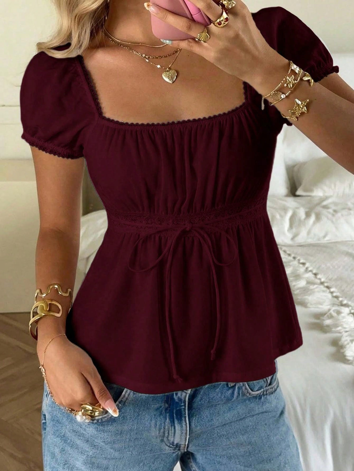 Women's black short puff sleeve top featuring a square neckline, ruched bust detail, and flared ruffle hem.