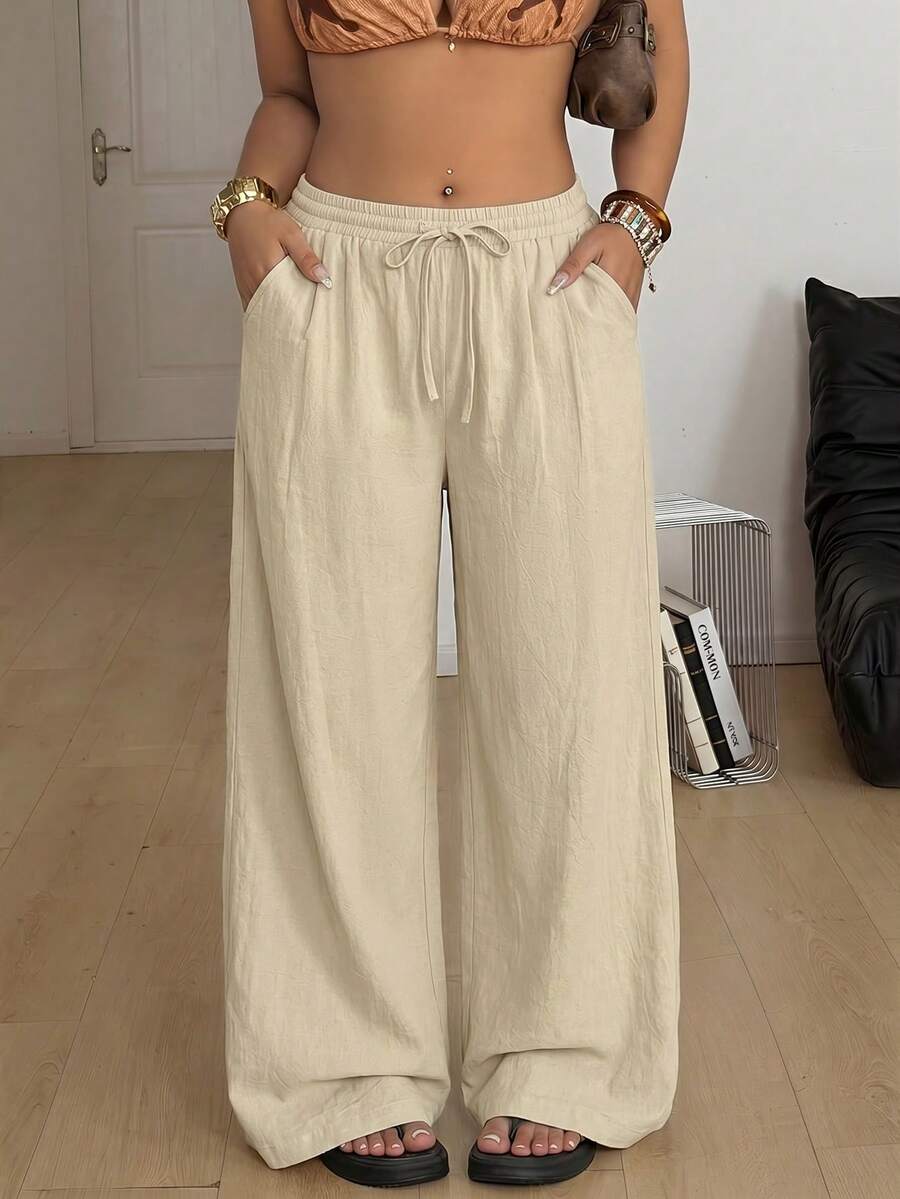 Women's loose straight leg cotton pants featuring a high waist with an adjustable drawstring knot and functional side pockets.