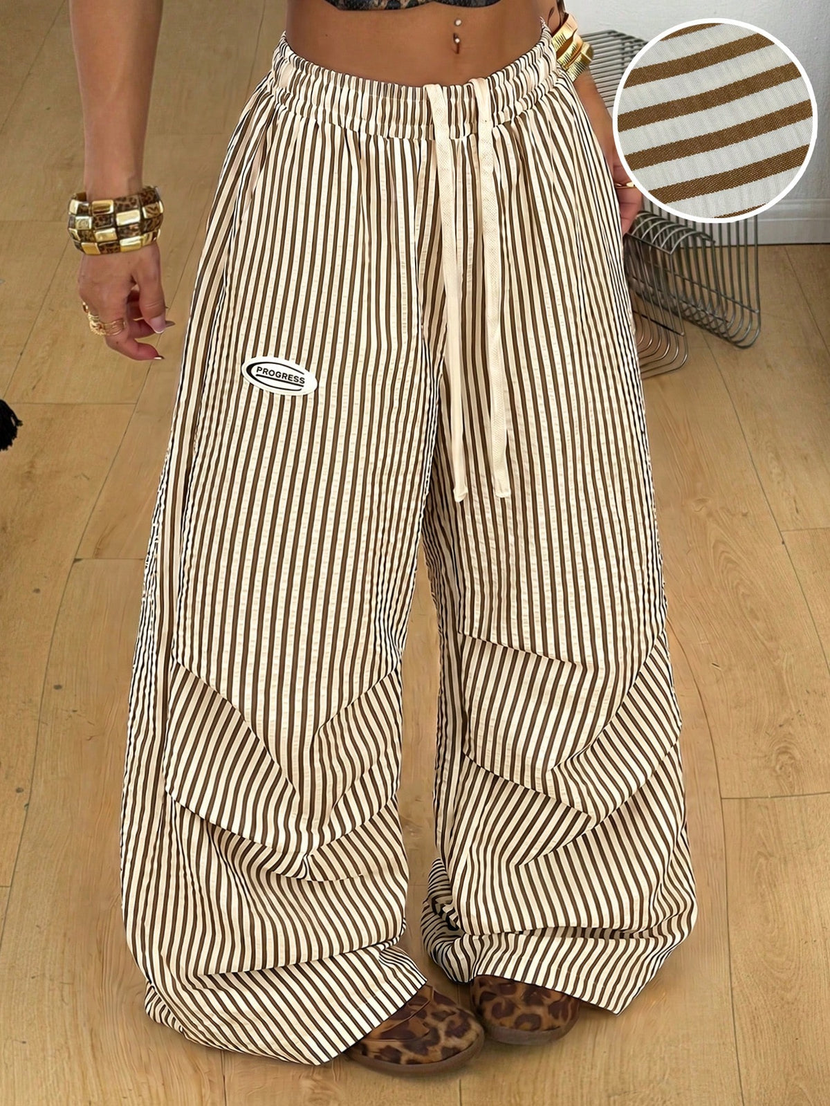 Women's black and white striped wide leg pants featuring an elastic drawstring waistband, side pockets, and a loose straight leg fit.