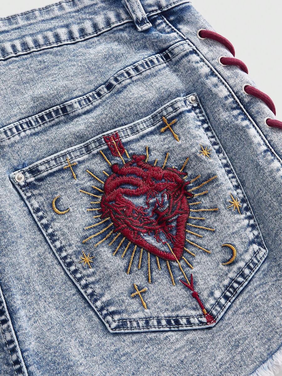 Plus size black gothic mini shorts with heart embroidery, graphic pocket pattern, lace-up detail, raw hem, and zipper fly
