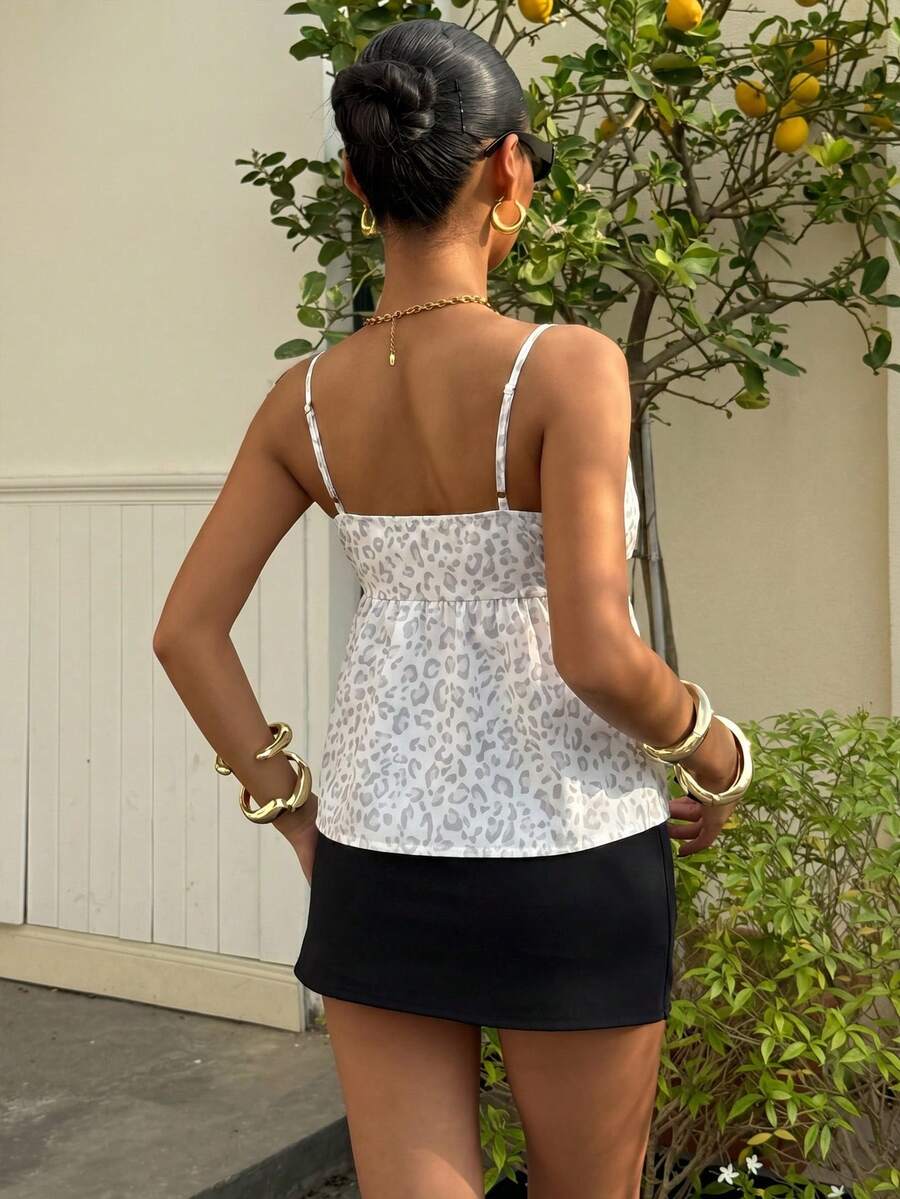 Women's casual geometric cami top with spaghetti straps, backless wrap styling, button front, and asymmetrical hem.