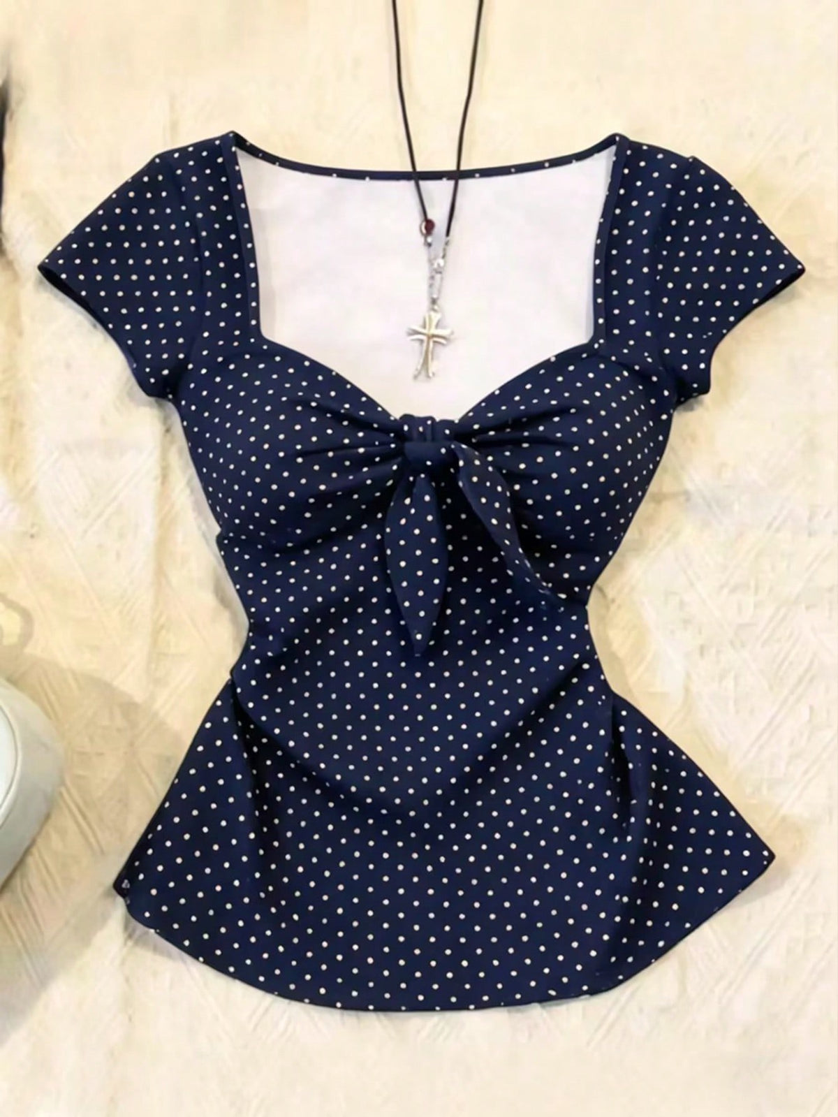 Women's polka dot short sleeve raglan t-shirt with a twist front detail and contrast collar.