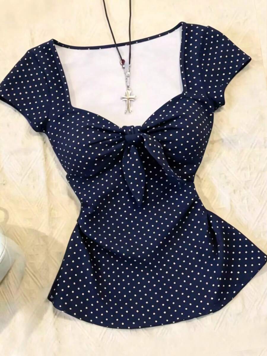 Women's polka dot short sleeve raglan t-shirt with a twist front detail and contrast collar.
