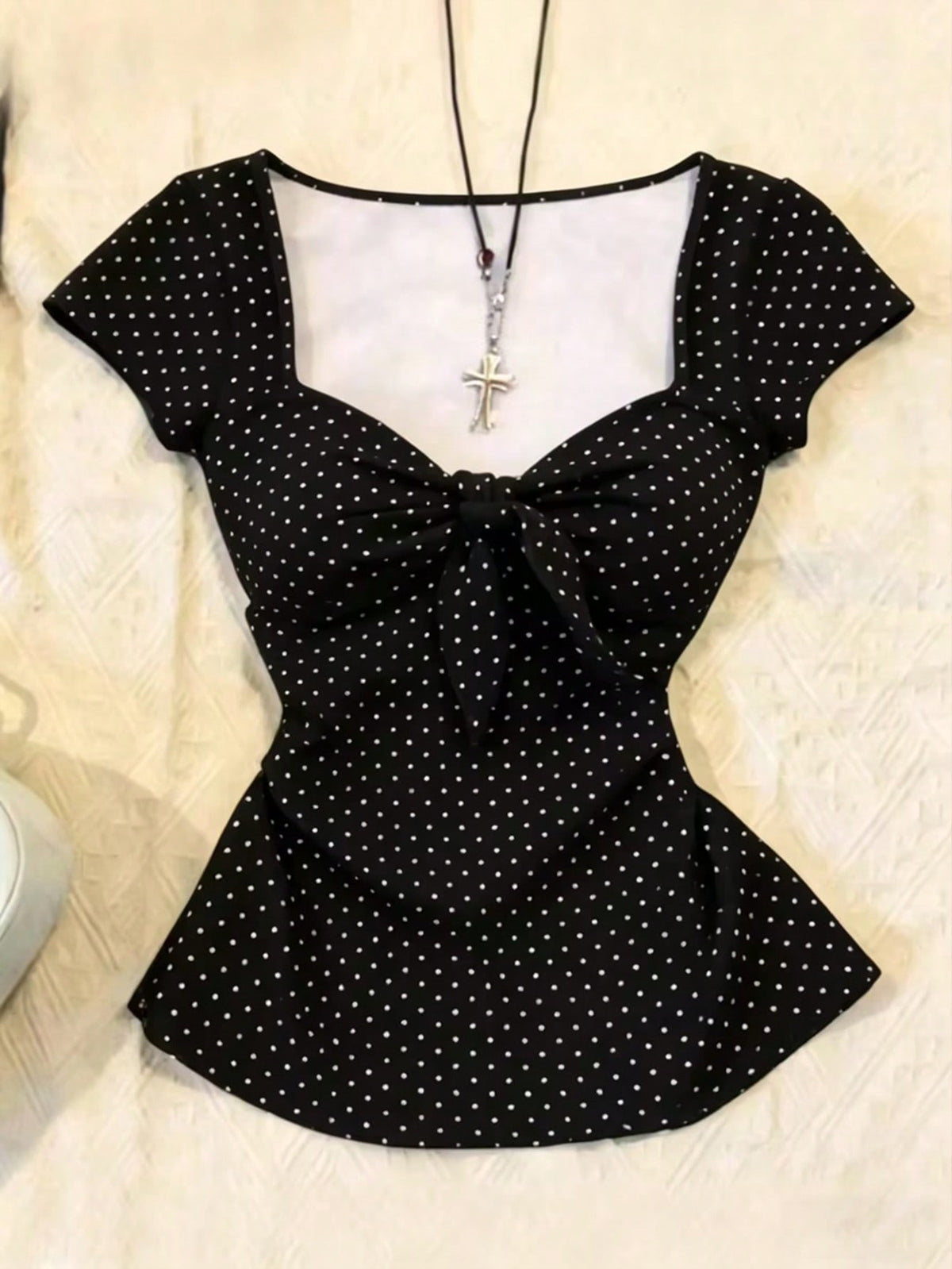 Women's polka dot short sleeve raglan t-shirt with a twist front detail and contrast collar.