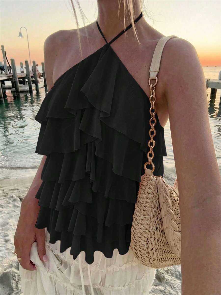 Women's sleeveless halter neck top featuring tiered ruffle layers, a backless cut, and an asymmetrical hem.