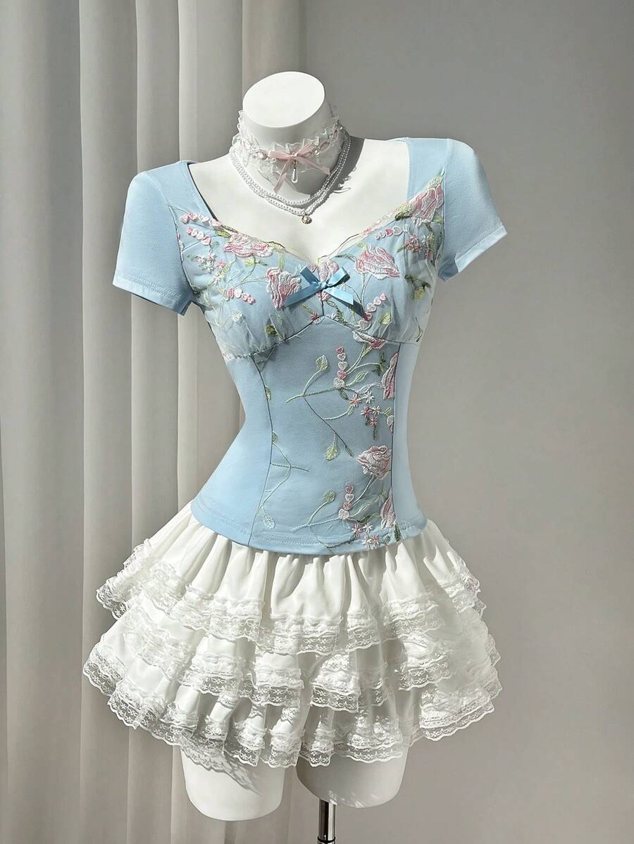 Women's pink short sleeve slim fit dress featuring a plant pattern, scoop neck, ruched appliques, and button front detail.