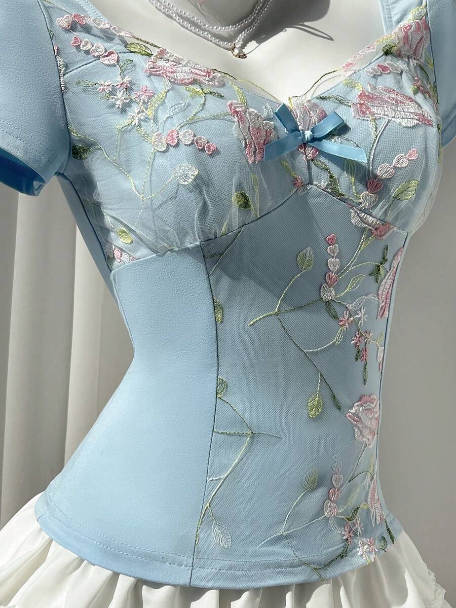 Women's pink short sleeve slim fit dress featuring a plant pattern, scoop neck, ruched appliques, and button front detail.