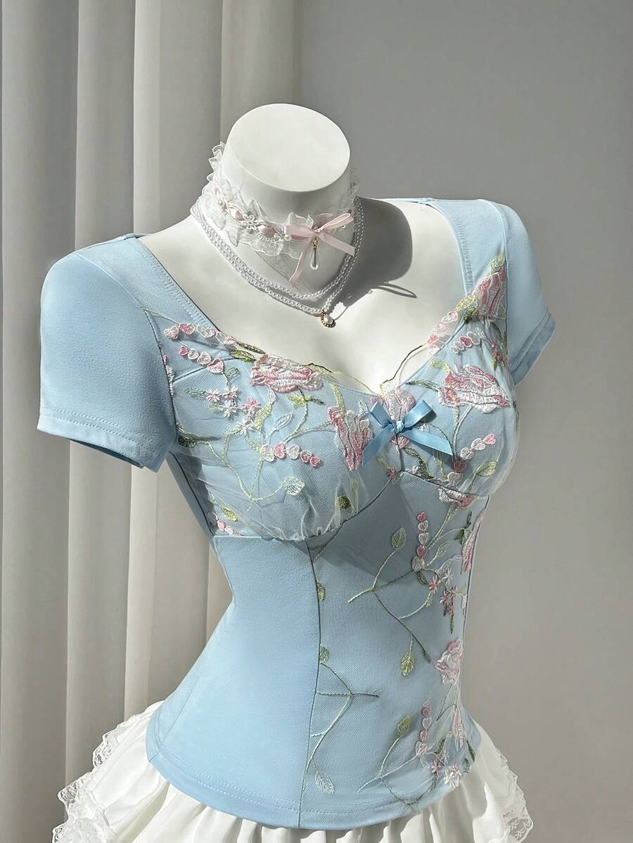 Women's pink short sleeve slim fit dress featuring a plant pattern, scoop neck, ruched appliques, and button front detail.