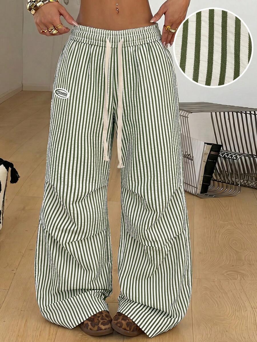 Women's black and white striped wide leg pants featuring an elastic drawstring waistband, side pockets, and a loose straight leg fit.