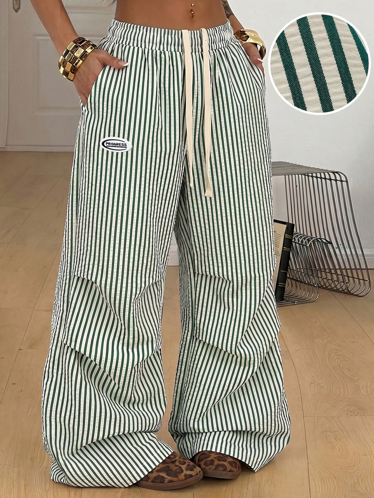 Women's black and white striped wide leg pants featuring an elastic drawstring waistband, side pockets, and a loose straight leg fit.
