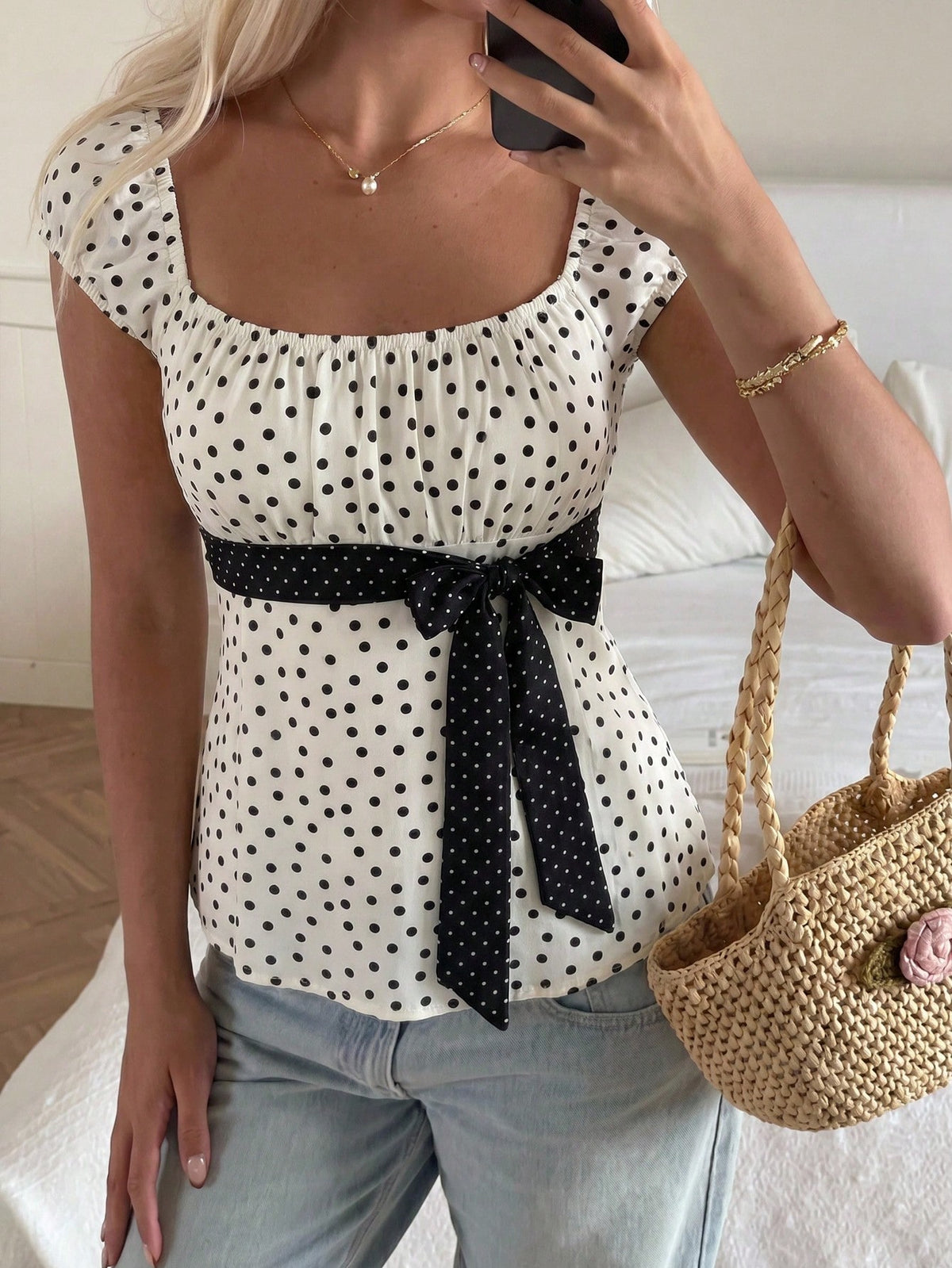 Women's short sleeve square neck polka dot top with ruched detailing, flared hem, and waist tie back.