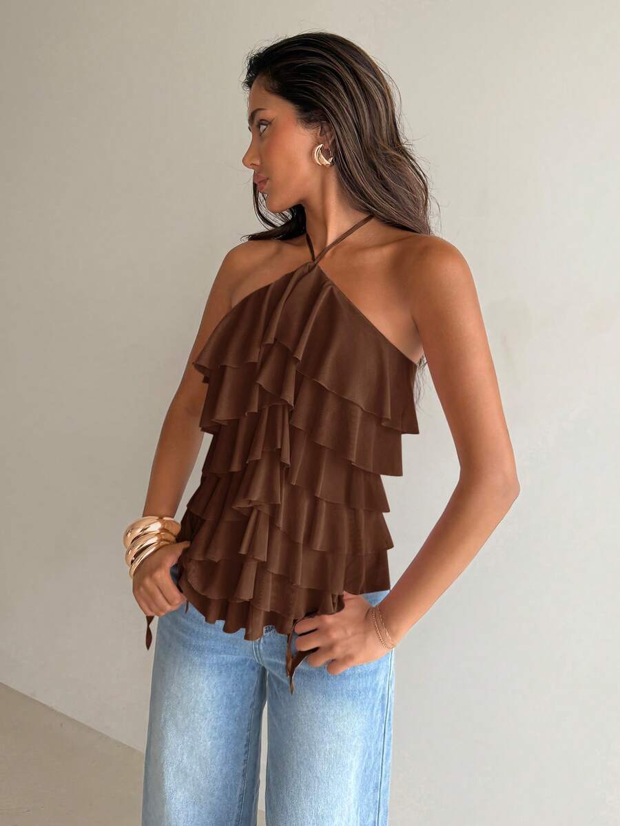 Women's sleeveless halter neck top featuring tiered ruffle layers, a backless cut, and an asymmetrical hem.