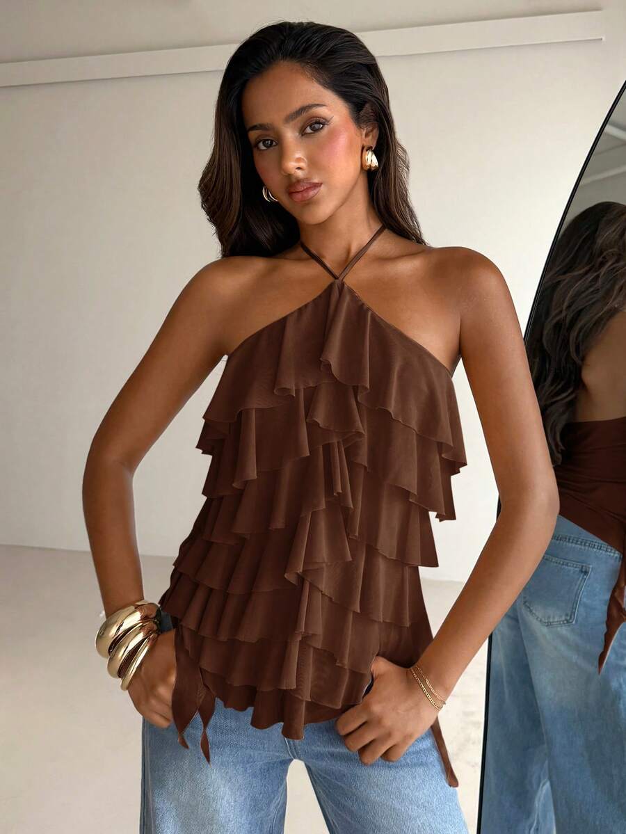 Women's sleeveless halter neck top featuring tiered ruffle layers, a backless cut, and an asymmetrical hem.