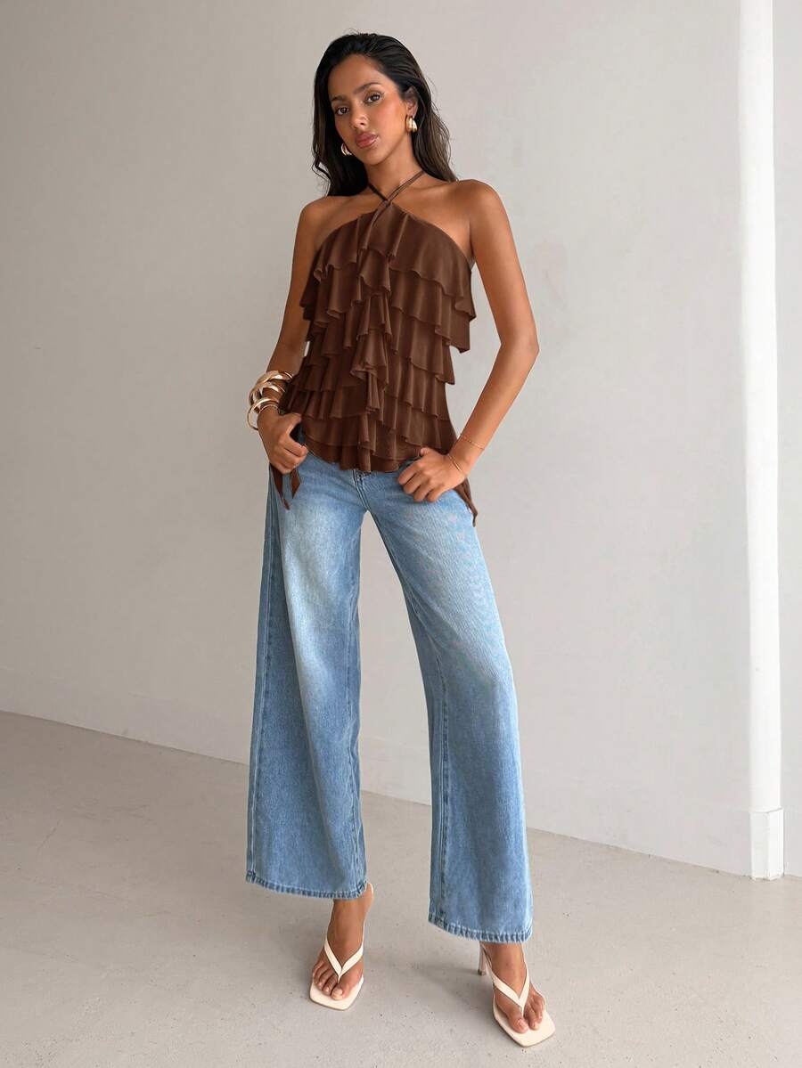 Women's sleeveless halter neck top featuring tiered ruffle layers, a backless cut, and an asymmetrical hem.