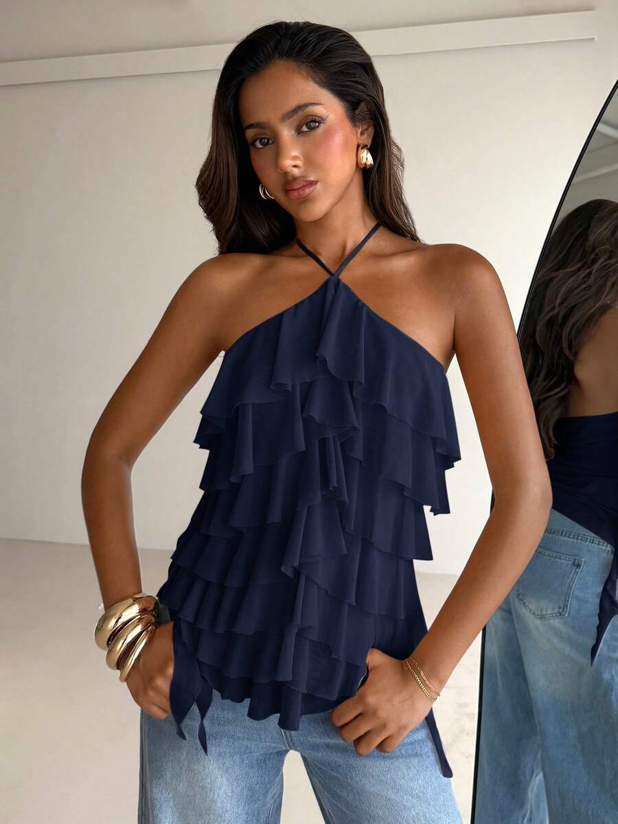 Women's sleeveless halter neck top featuring tiered ruffle layers, a backless cut, and an asymmetrical hem.