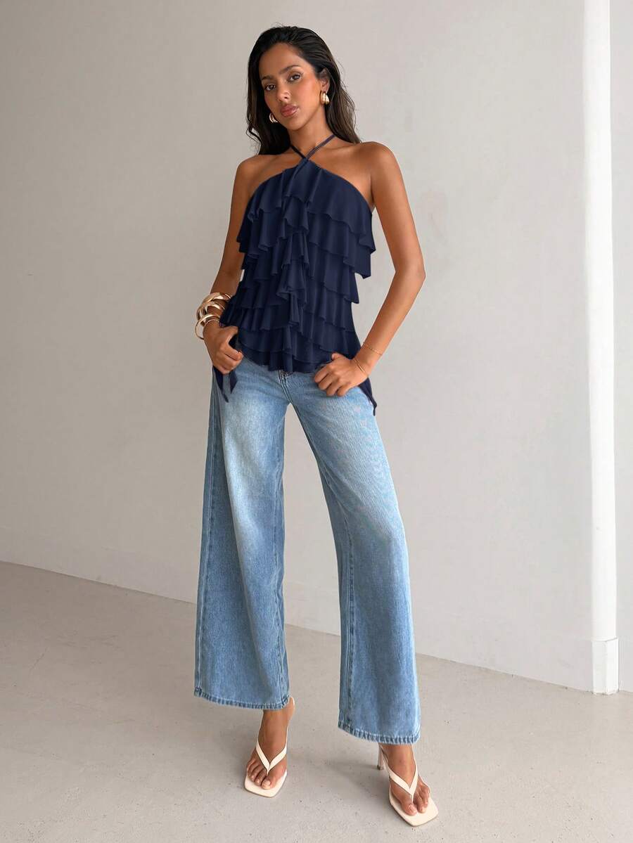 Women's sleeveless halter neck top featuring tiered ruffle layers, a backless cut, and an asymmetrical hem.