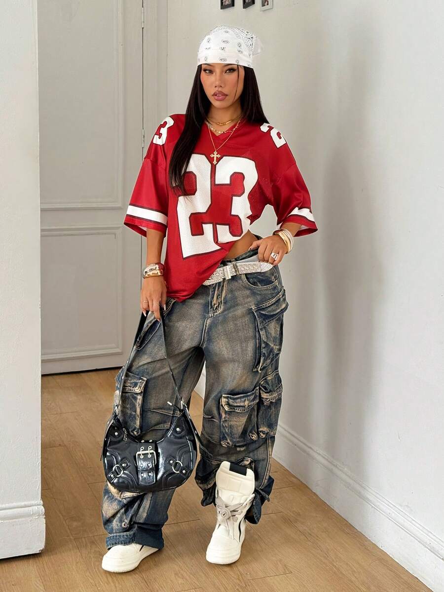 Oversized short-sleeve football jersey top featuring a V-neckline, contrast binding, and graphic number print.