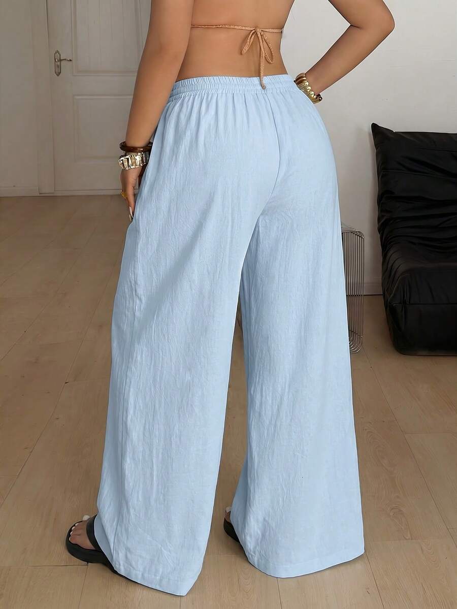 Women's loose straight leg cotton pants featuring a high waist with an adjustable drawstring knot and functional side pockets.