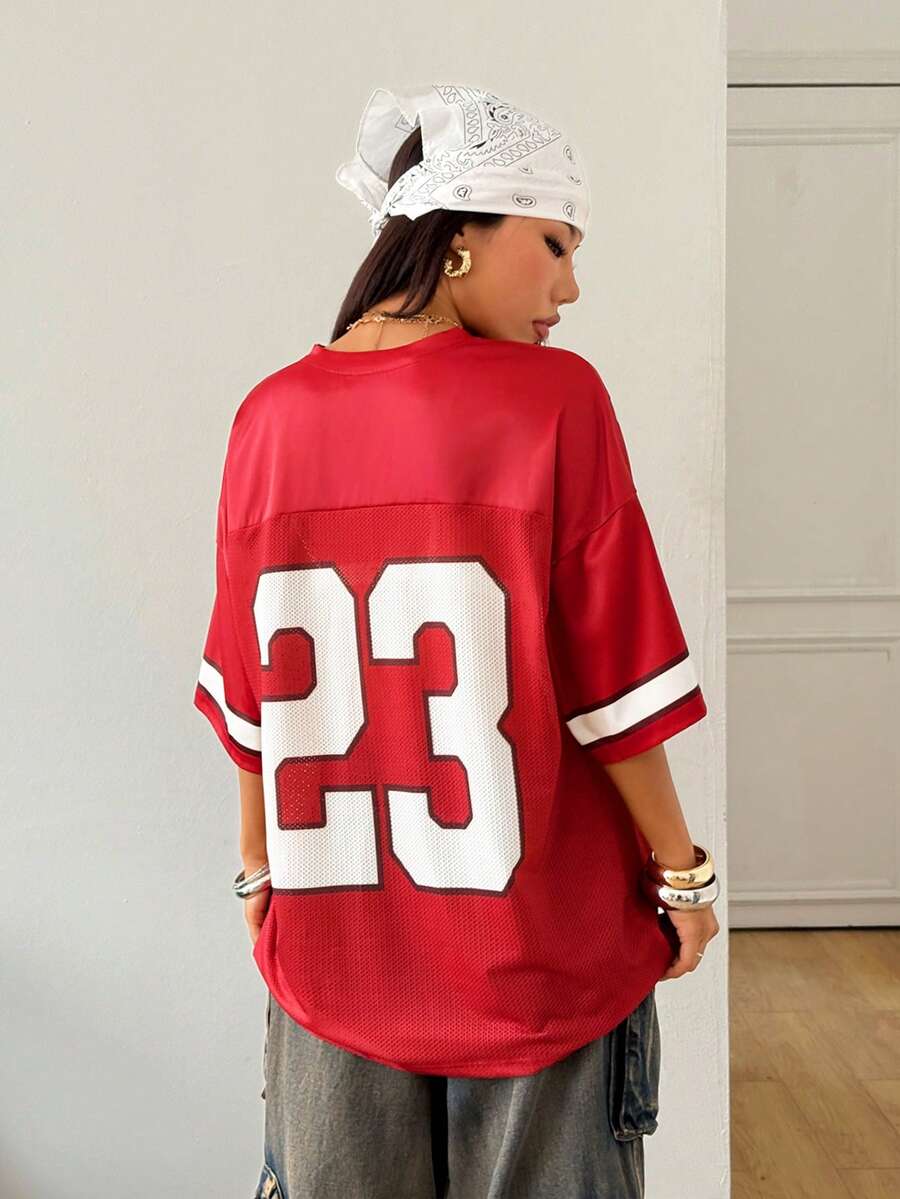 Oversized short-sleeve football jersey top featuring a V-neckline, contrast binding, and graphic number print.